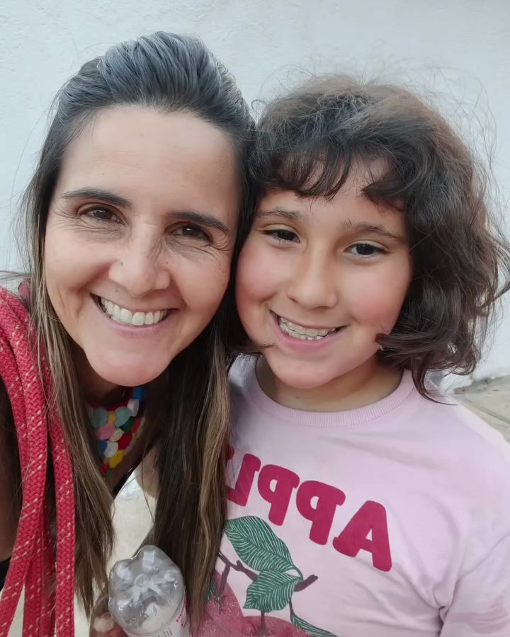 Professora Emília abraçada com uma aluna do Quintal