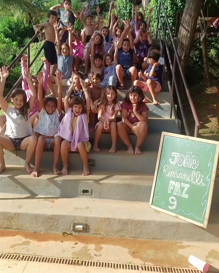 Turma de crianças comemorando um aniversário na escadaria do Quintal