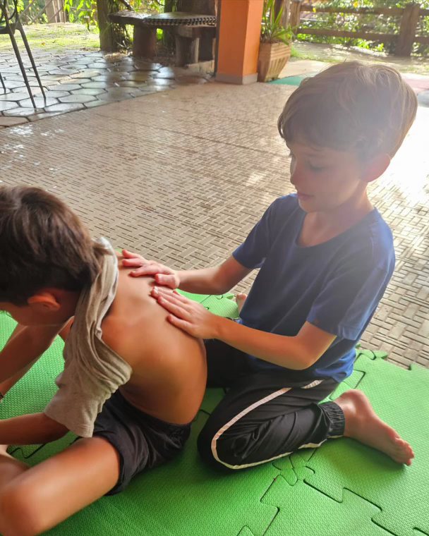 Vivência de yoga com massagem entre as crianças no Quintal