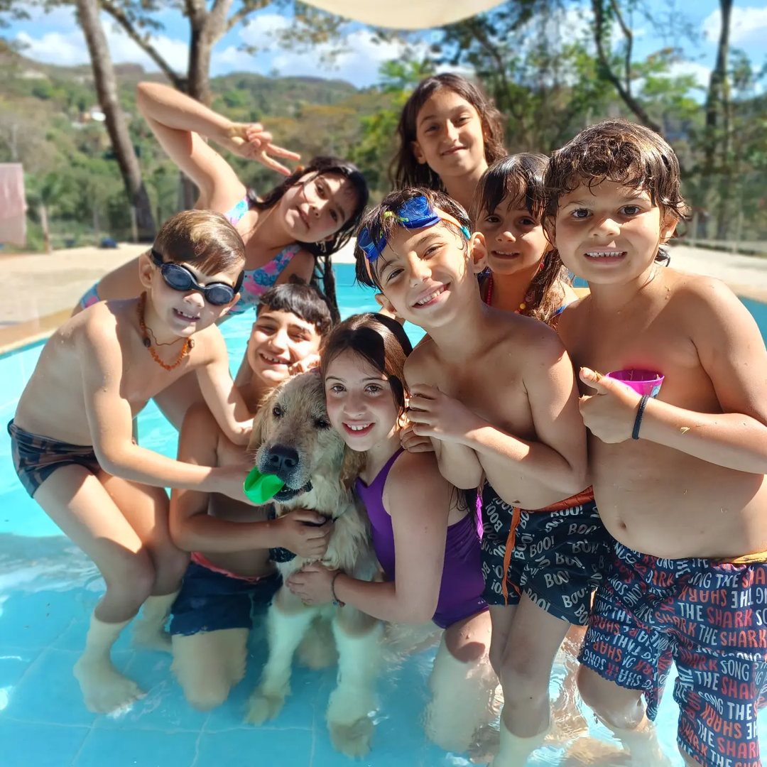Turma do Quintal reunida sorrindo na piscina com o cachorro