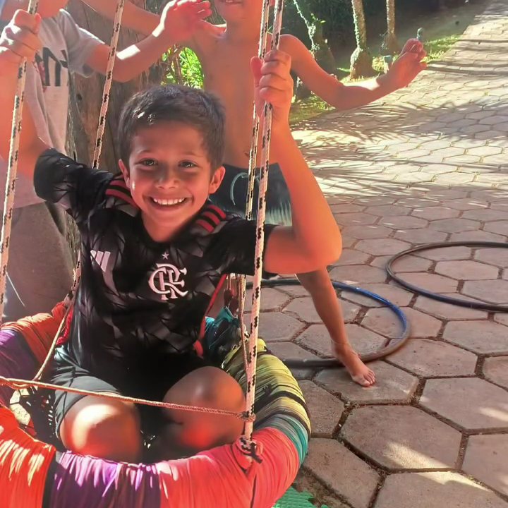 Menino sorrindo no balanço ninho