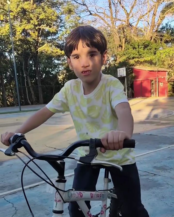 Menino andando de bicicleta nas Férias no Quintal